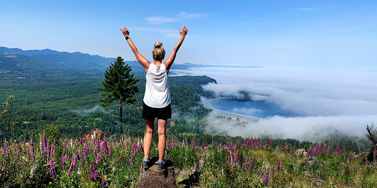 Woman celebrating at the top of a mountain