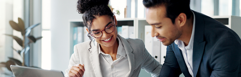 Business partners collaborate at a laptop