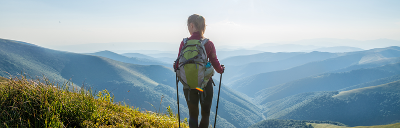 Woman hiking at crest of mountain