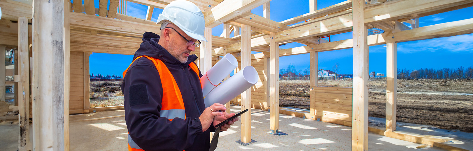 Man in construction site looking at tablet