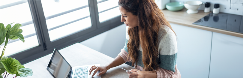 A woman contemplates a purchase with her credit card