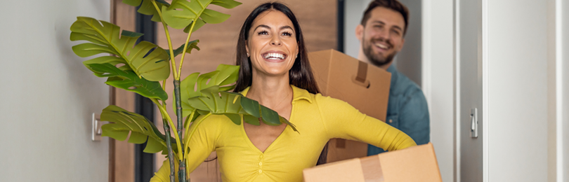 A couple moves boxes into their new home